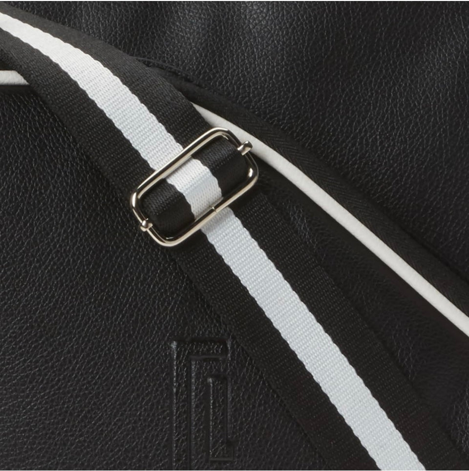 Introducing the SamLouise England 68 Pickleball Bag: a chic red bag crafted from eco-friendly vegan leather. It features zippered pockets and a shoulder strap adorned with white accents, all showcased against a pristine white background.