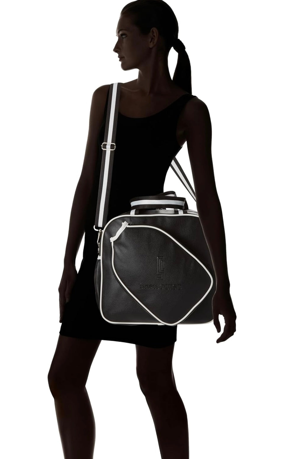 Introducing the SamLouise England 68 Pickleball Bag: a chic red bag crafted from eco-friendly vegan leather. It features zippered pockets and a shoulder strap adorned with white accents, all showcased against a pristine white background.
